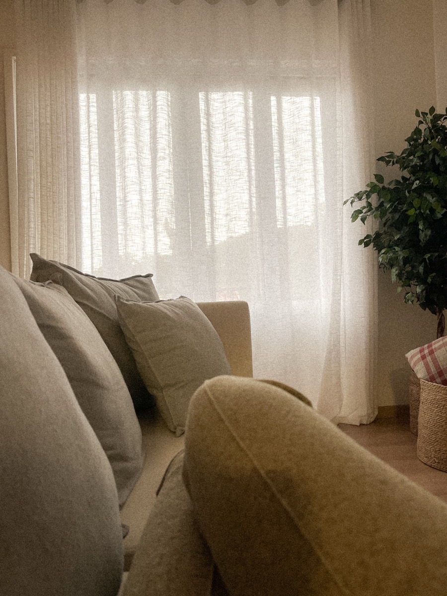 Calm living room with a linen sofa, sheer curtains and soft natural light