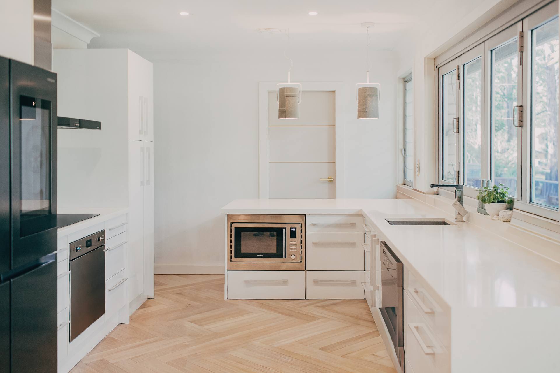 Renovated Castle Hill kitchen with white cabinetry, a central island and herringbone parquetry flooring