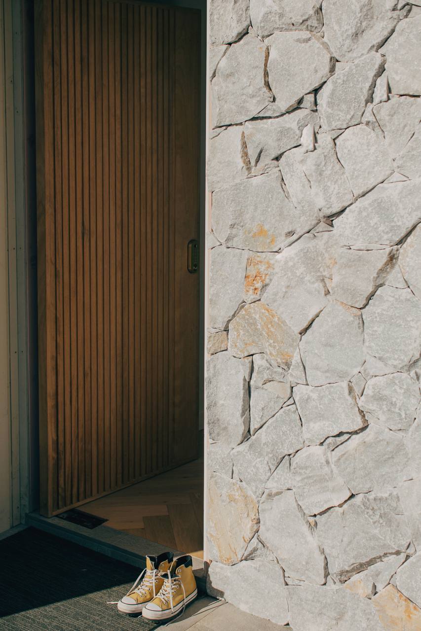 Natural stone accent wall and timber screen at the entry of the Castle Hill home