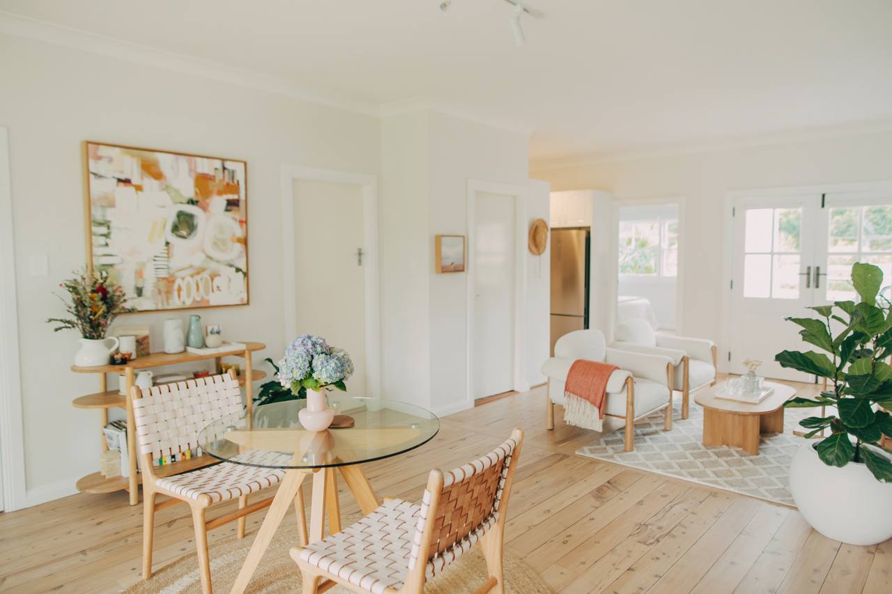 Open-plan dining and living area with timber flooring and natural light