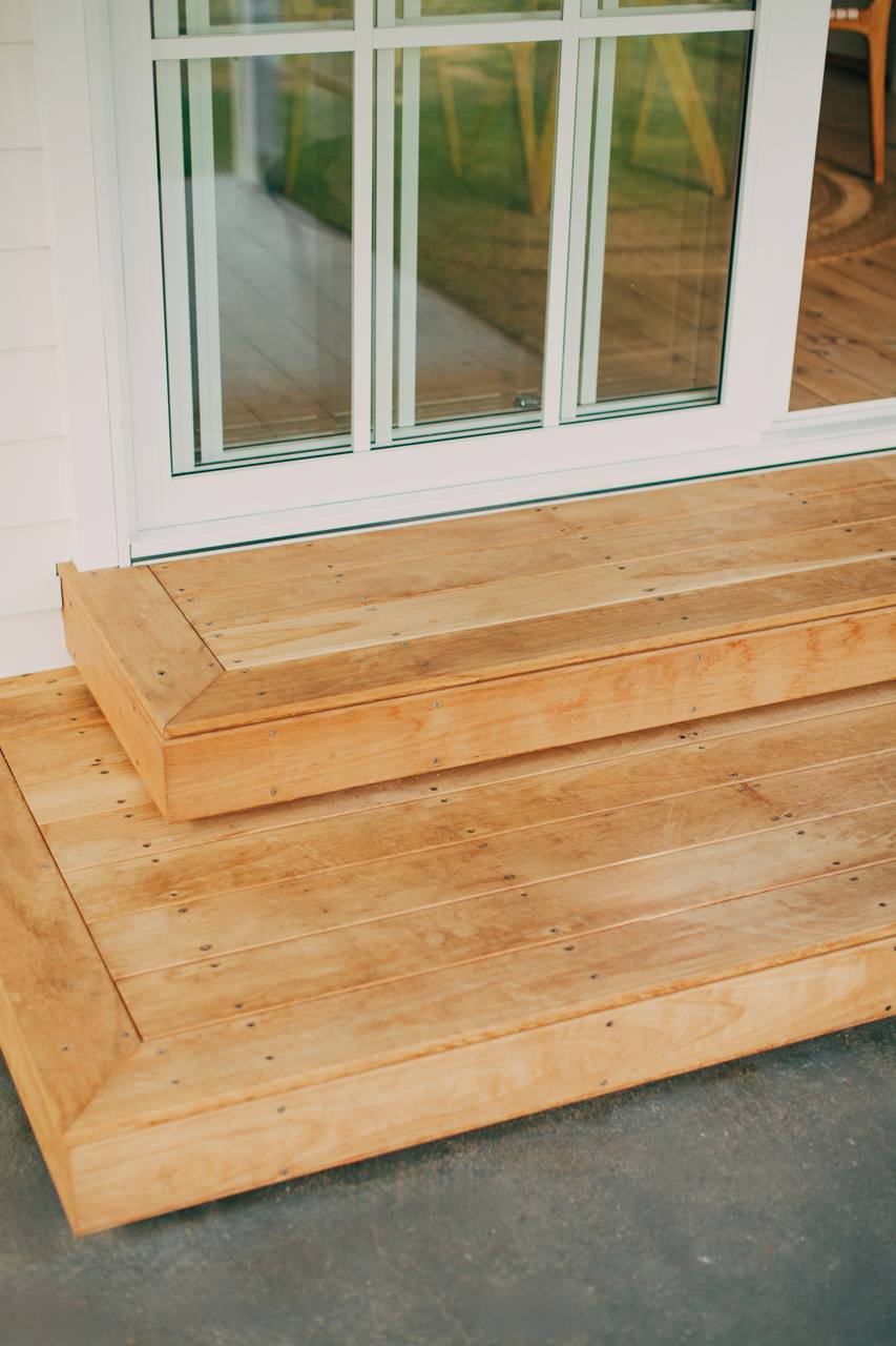 Timber deck steps leading up to the aluminium French doors at the North Narrabeen home