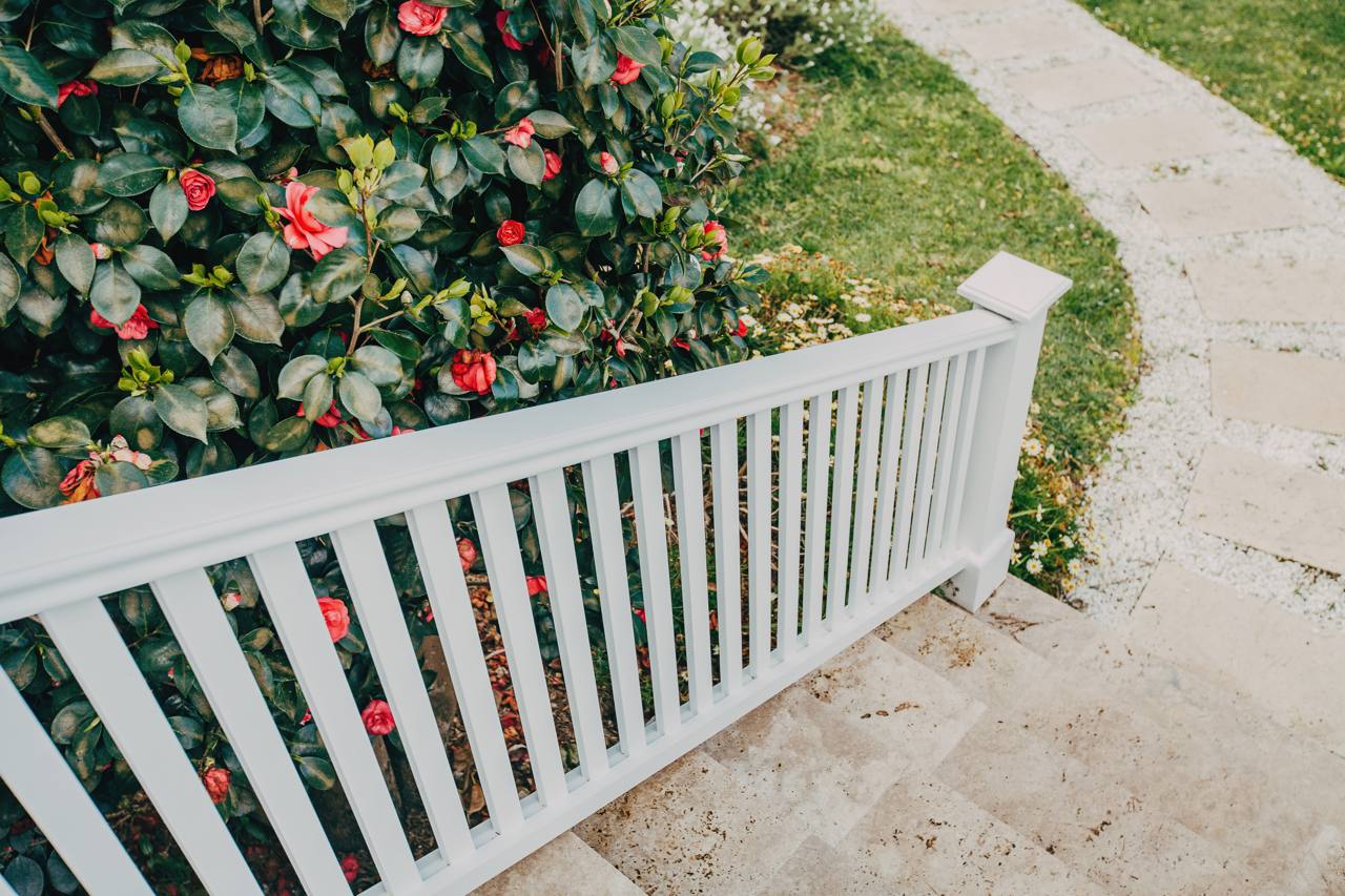 New driveway and white picket fence framed by the established camellia garden at the Pymble home