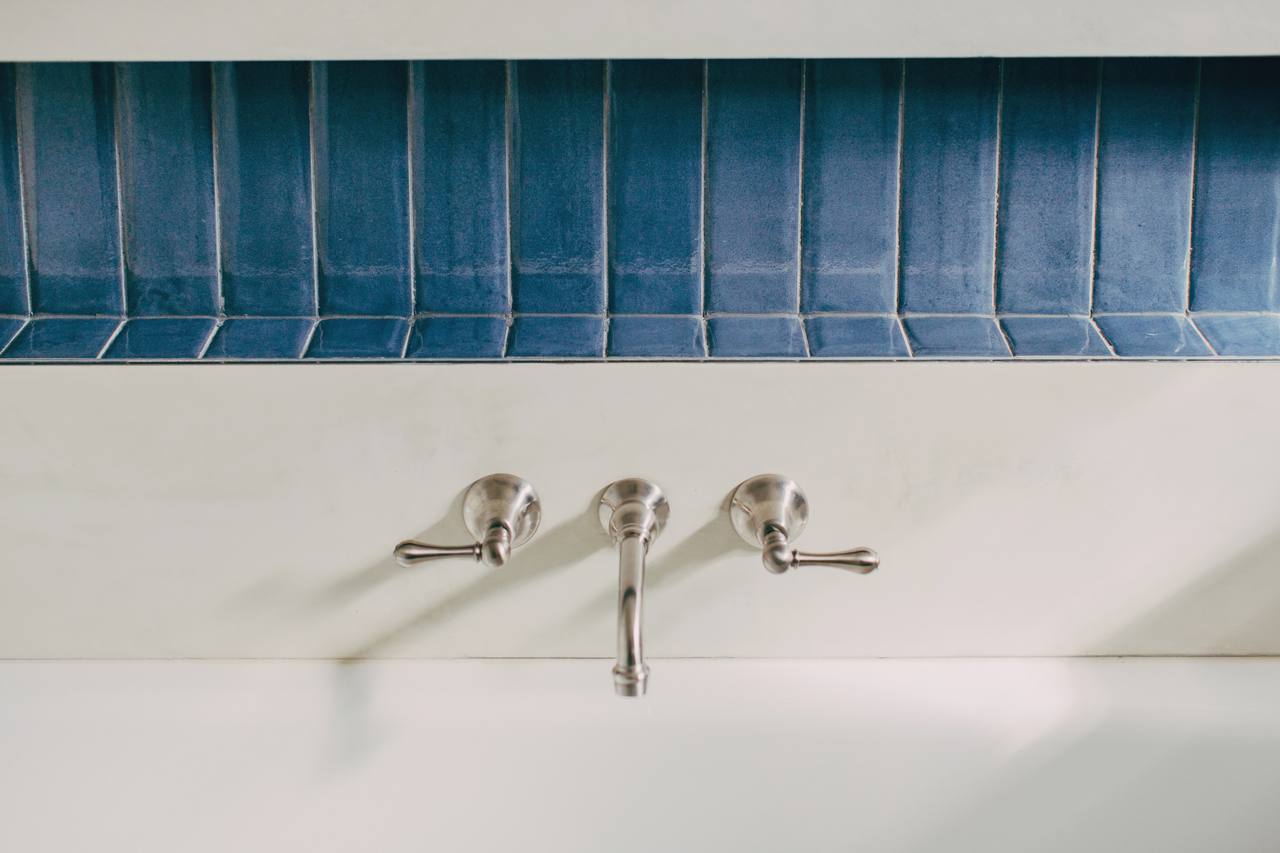Venetian micro-cement surface detail with wall-mounted brass tapware in the Pymble bathroom